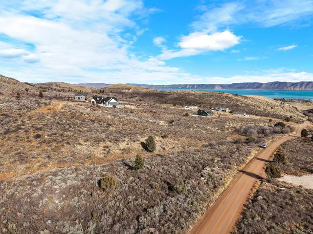 Expansive property featuring a contemporary residence, additional structures, and surrounding natural terrain