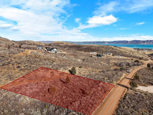 Expansive undeveloped land parcel with natural vegetation and a prominent dirt road