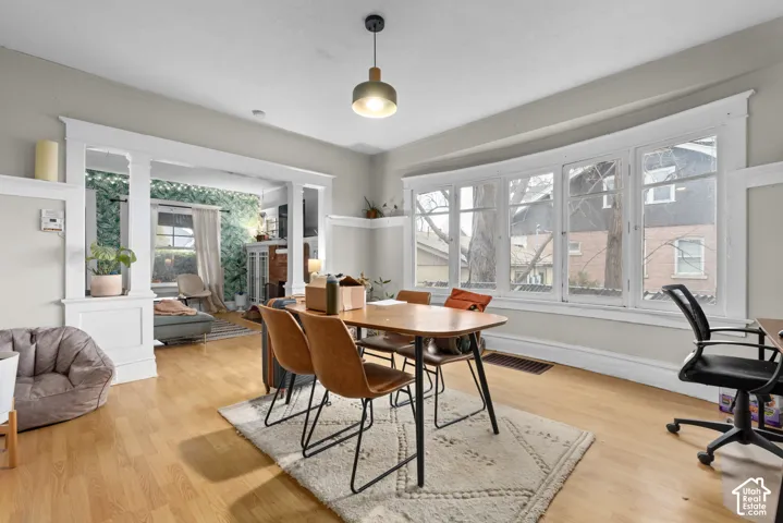 Light wood-finish flooring throughout, featuring a curved bay window with multiple panes