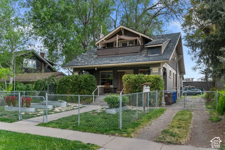 Craftsman-style residence with a prominent gabled roof, covered porch, and second-story balcony