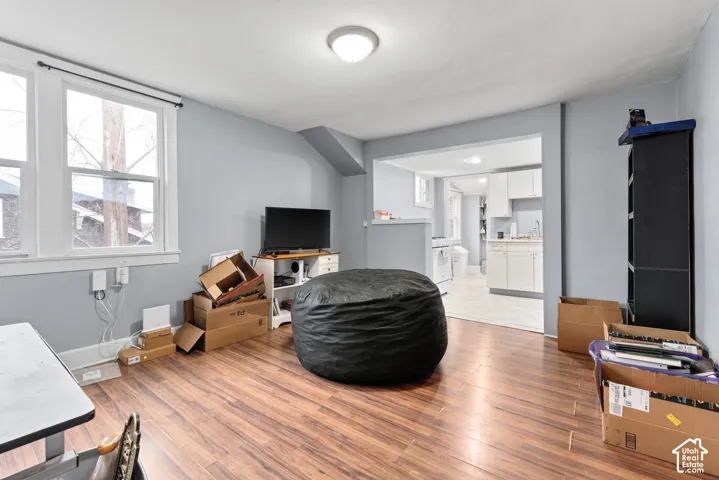 Wood-finish flooring throughout, light blue wall paint, and two windows with white trim