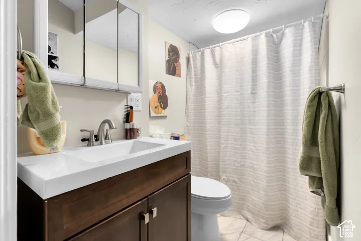 Modern bathroom featuring a floating wood-finish vanity with an integrated white rectangular sink, chrome faucet, and ample storage below