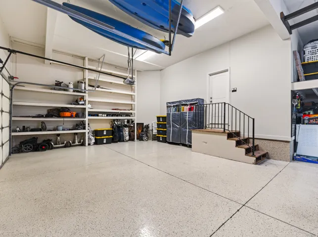 Epoxy-coated flooring, built-in shelving, white walls, overhead lighting, and interior access door