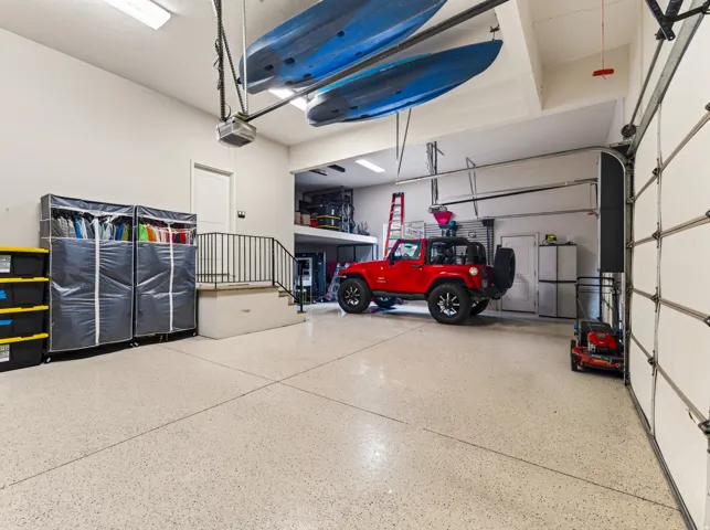 Spacious garage with an epoxy-coated floor, overhead storage, and a multi-level layout
