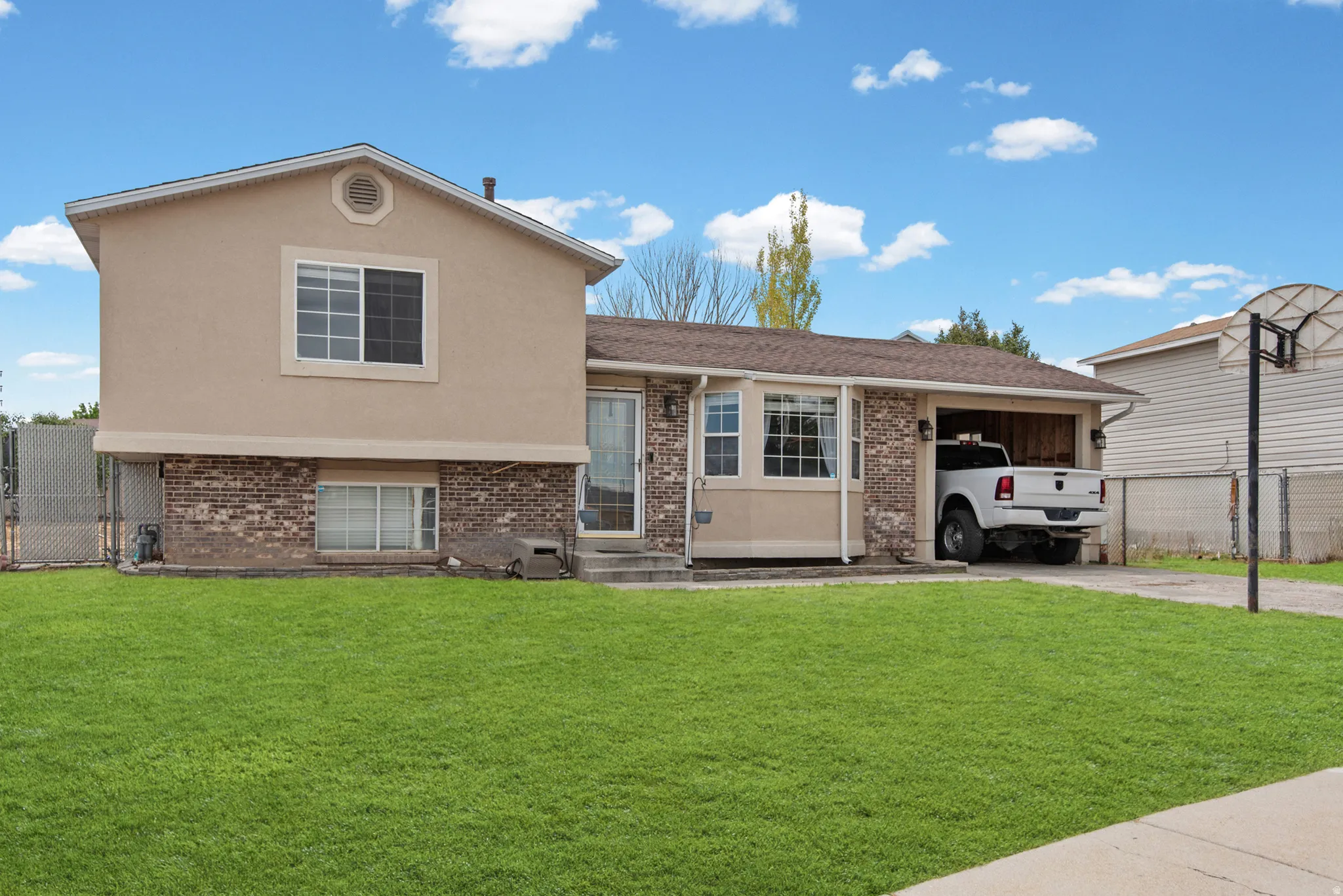 Stucco and brick exterior with a front entry door, bay window, and attached single-car garage