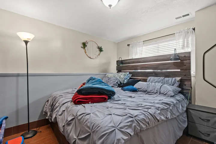 Window with blinds, wood-finish flooring, two-tone wall paint, and a ceiling-mounted light fixture