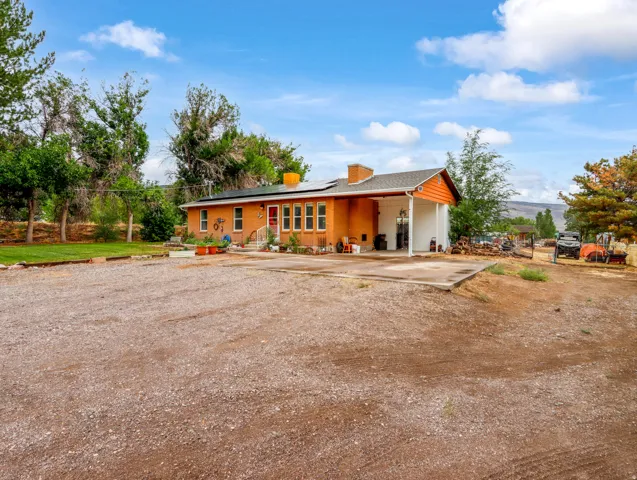Charming orange brick residence with a sprawling gravel forecourt and mature landscaping