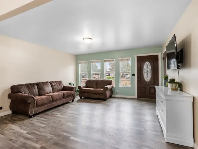 Wood-finish flooring, multiple windows, a recessed entry, and a ceiling-mounted light fixture