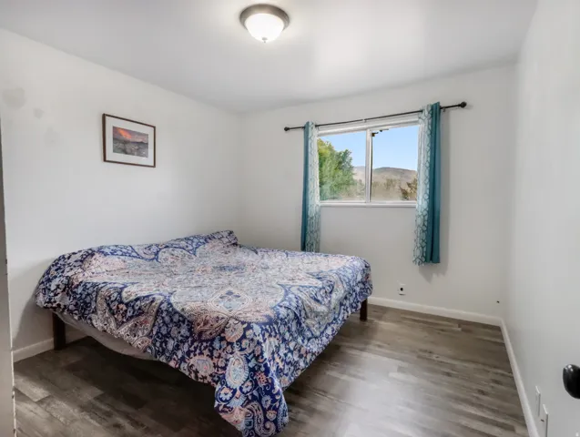 Wood-finish flooring, white walls, and a window with a mountain backdrop