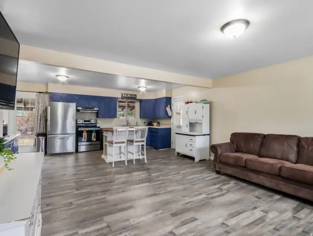 Open-concept layout featuring wood-finish flooring, recessed lighting, and a kitchen island with seating
