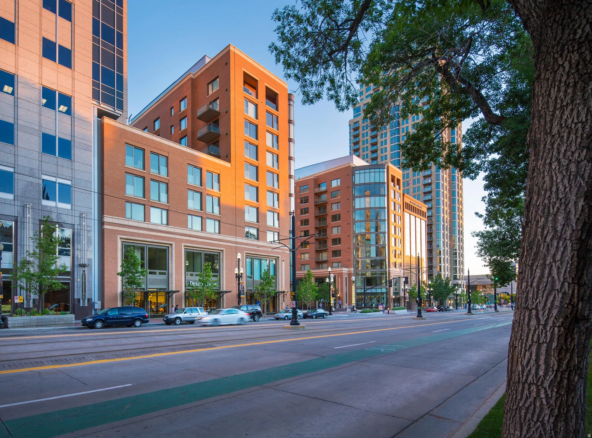 High-rise building featuring a red brick facade with balconies and a stone and glass exterior