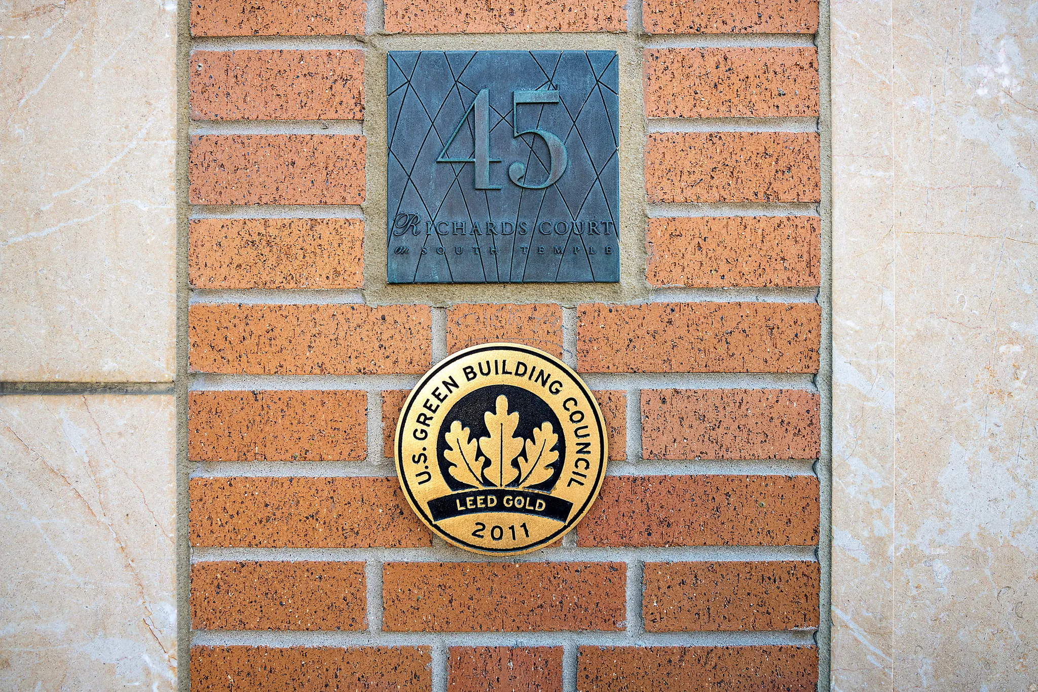 Brick and stone exterior detailing with a bronze address plaque and LEED Gold certification
