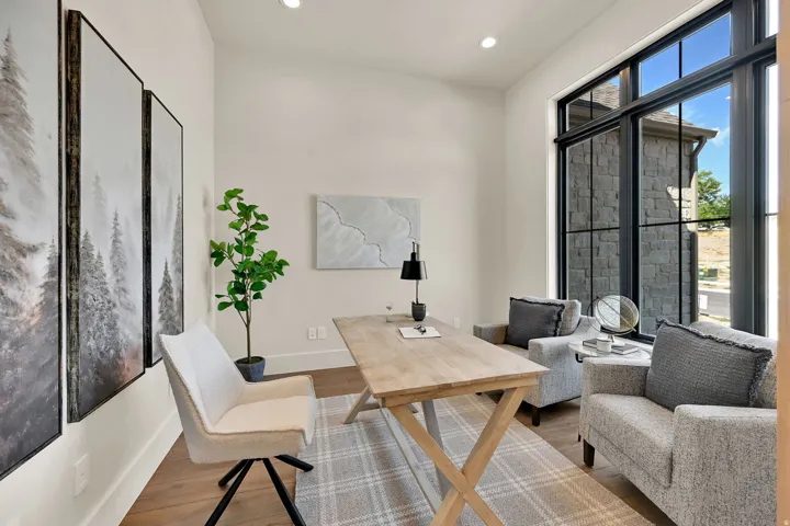 Window wall with black framing, wood-finish flooring, recessed lighting, and crisp white walls