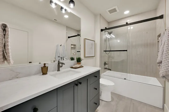 Bathroom featuring a vanity with dark cabinetry, integrated sink, and white countertop