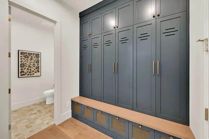 Built-in cabinetry with dark panel doors, brass hardware, and integrated seating