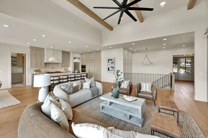 Vaulted ceilings with exposed beams, open-concept living area, recessed lighting, wood-finish flooring, and a kitchen island with pendant lighting
