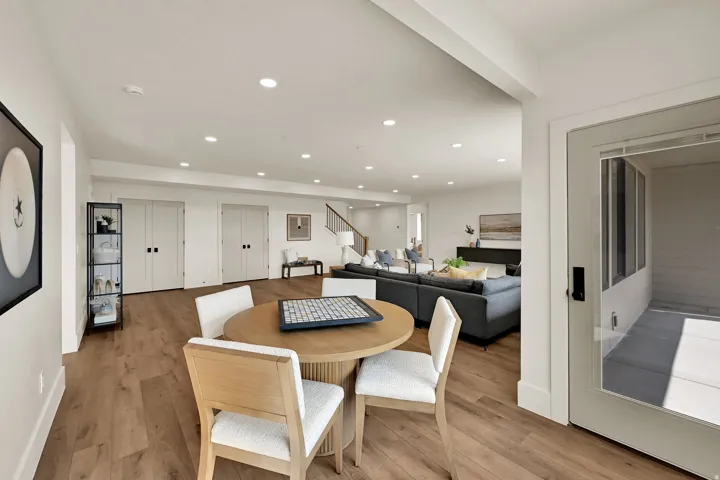 Open concept living space featuring recessed lighting, wood-finish flooring, and crisp white walls