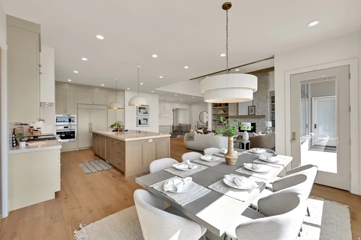 Open-concept living space featuring wood-finish flooring, recessed lighting, and a tiered drum chandelier
