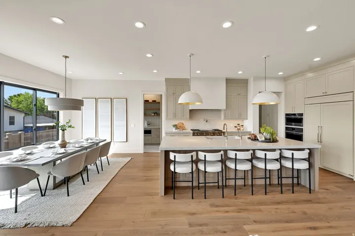 Open-concept living space with wood-finish flooring, a kitchen island with seating, pendant lighting, and recessed lighting