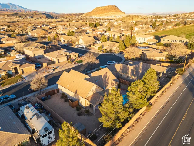 Residences with pitched roofs and attached garages, surrounded by desert landscaping and mature trees