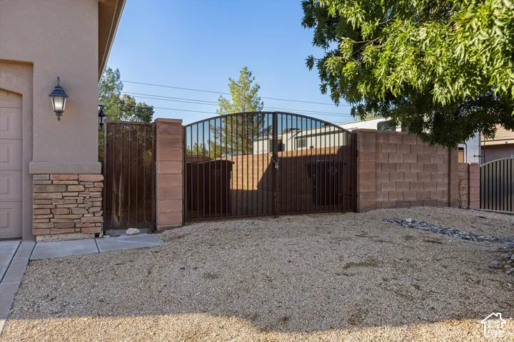 Stucco exterior with stone veneer accents, an exterior wall lantern, and a gravel-covered ground