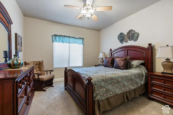 Carpeted room with vaulted ceiling and a ceiling fan