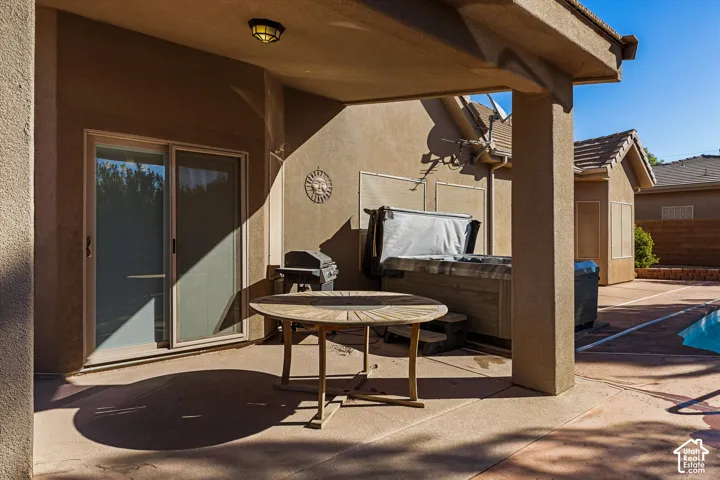 Covered patio with a sliding glass door, a built-in spa, and a pool with concrete decking