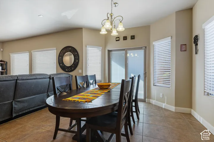Recessed lighting, sliding glass door, multiple windows with horizontal blinds, tiled flooring, chandelier lighting fixture
