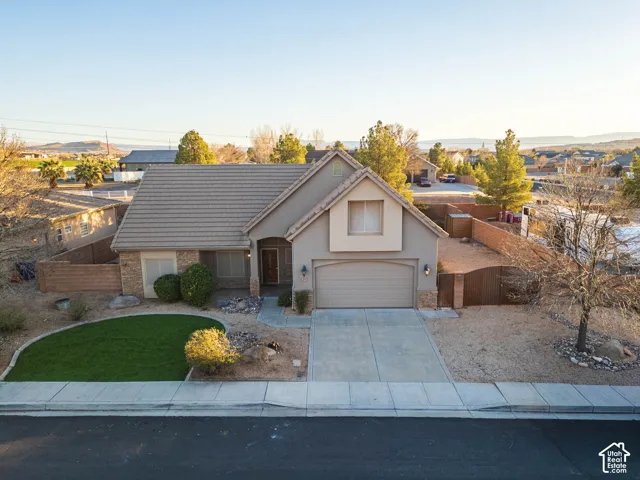 Southwestern-style home featuring a concrete driveway, attached garage, and a tiled roof