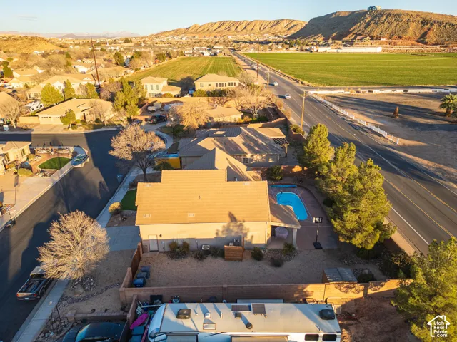 In-ground swimming pool, desert landscaping, paved patio area, mature trees, mountain backdrop
