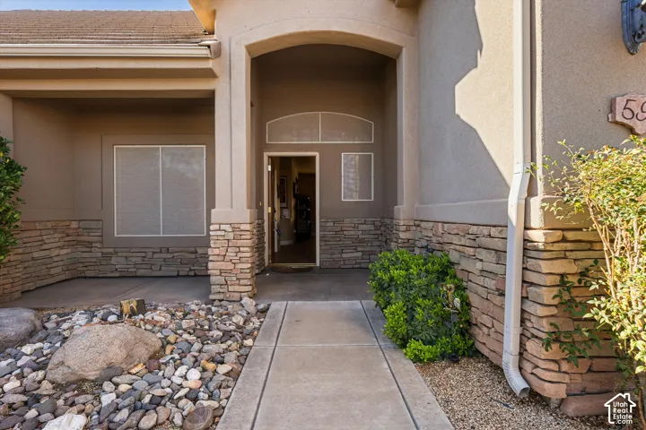 Front entry featuring a stone facade and arched portico