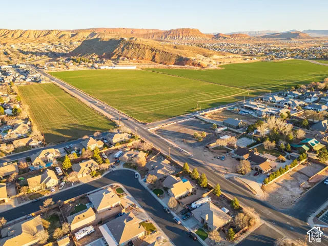 Expansive green fields with distant rugged mountains