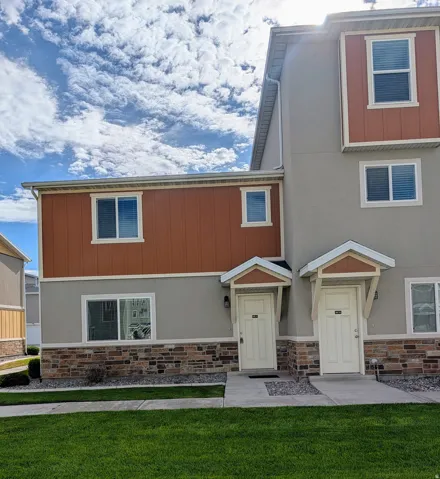 Multi-level exterior with a mixed material facade including stucco, horizontal siding, and stone accents