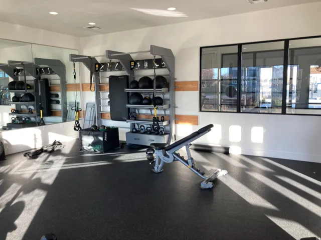 Full-length wall mirror, black-framed windows, recessed lighting, and rubber flooring