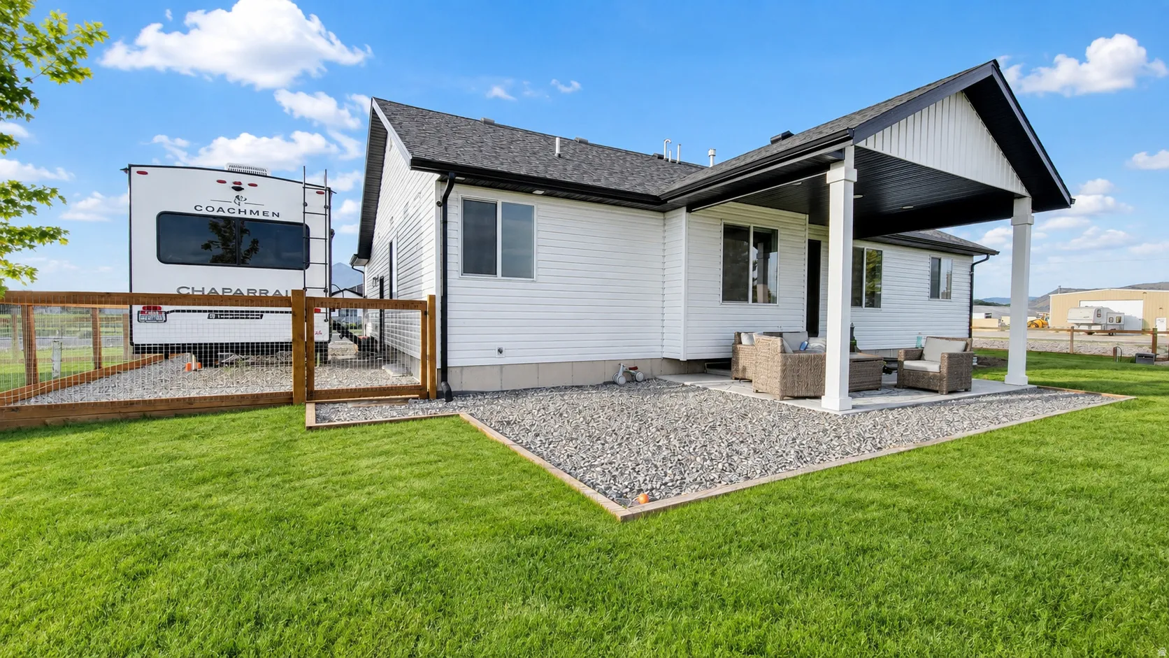 Expansive lawn with a gravel patio area and a covered outdoor living space