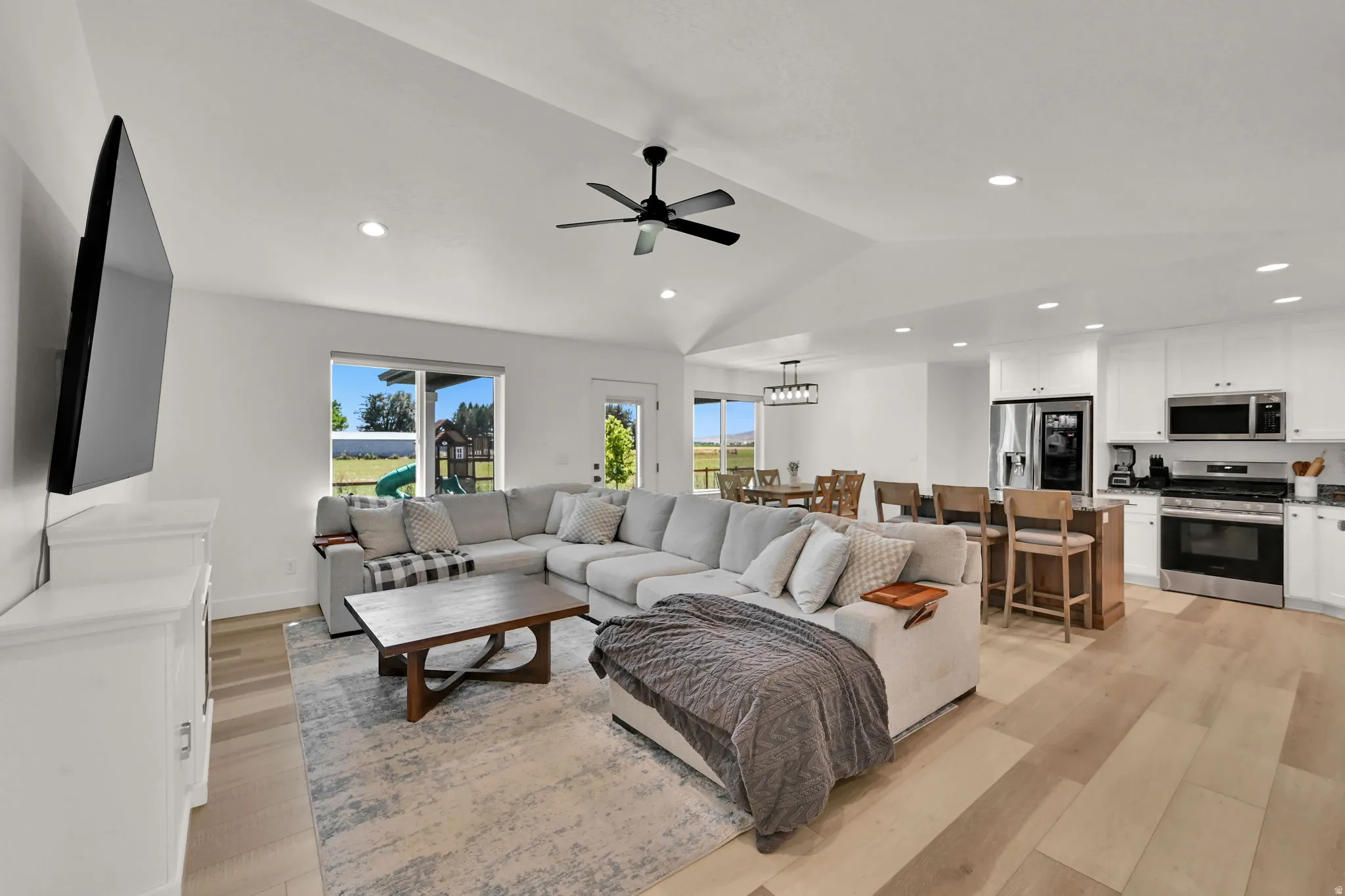 Vaulted ceilings, recessed lighting, and light wood-finish flooring