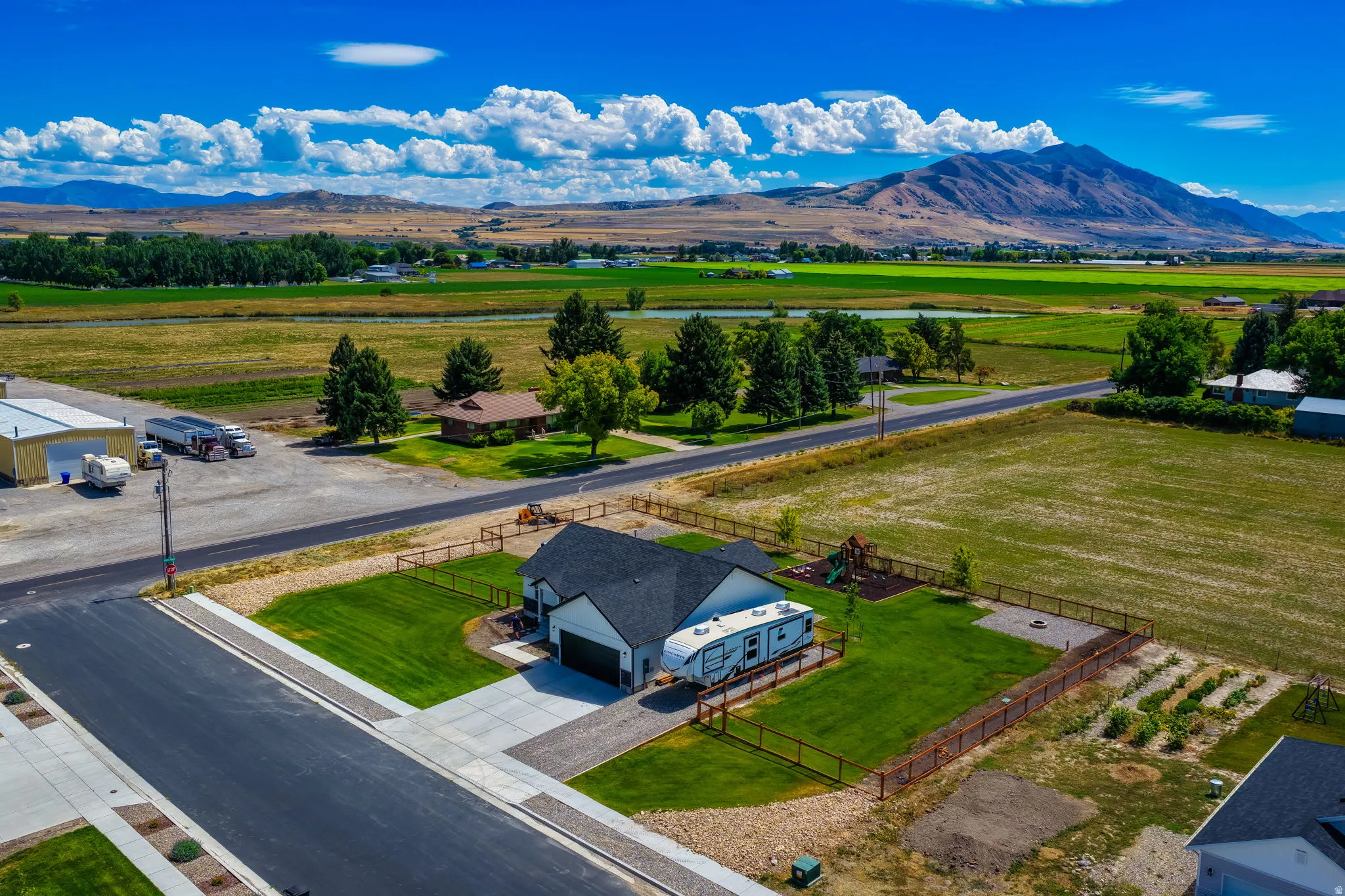 Single-story residence with an attached garage, concrete driveway, and fenced yard featuring a grassy lawn