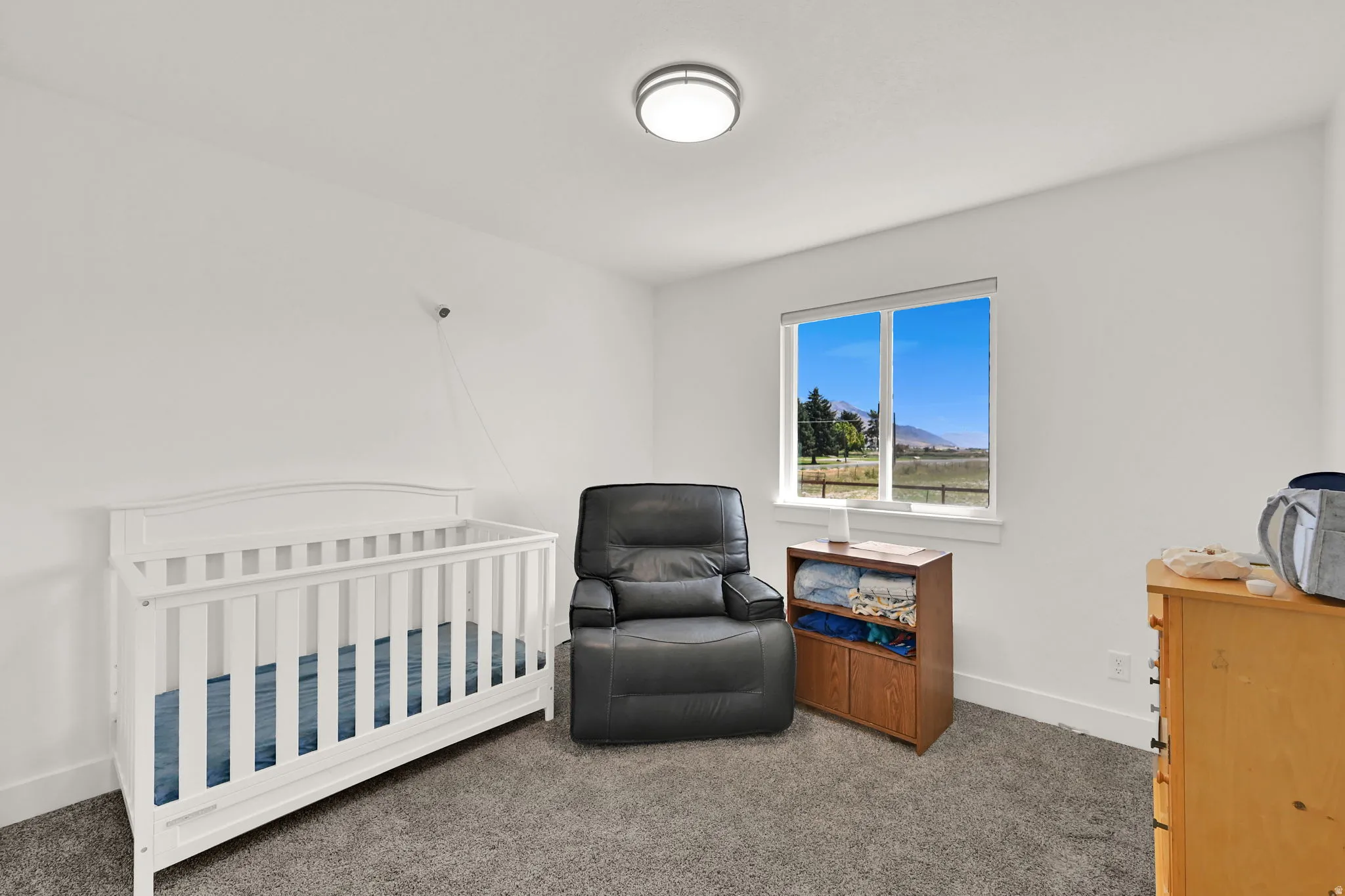 Recessed lighting, large window, mountain backdrop, and neutral wall paint