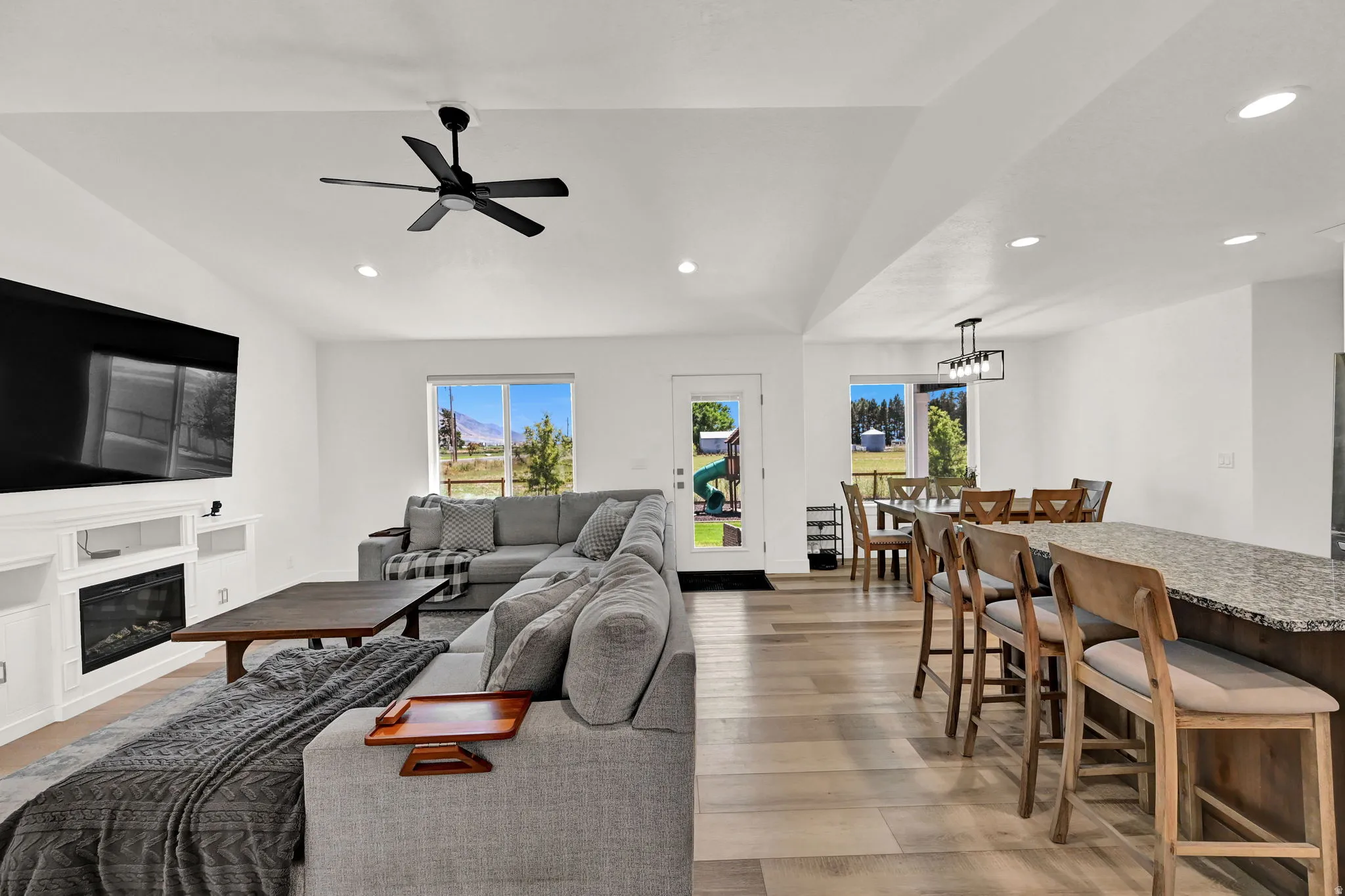 Spacious living area featuring high vaulted ceilings, recessed lighting, and wood-finish flooring