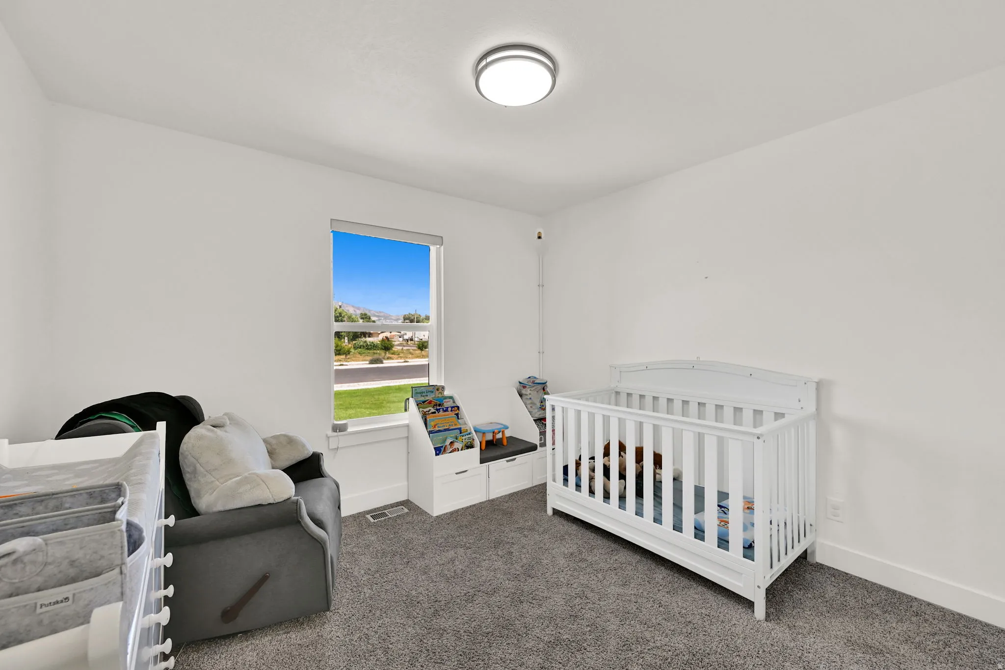 Window with natural scenery, built-in storage bench, and flush-mount ceiling light