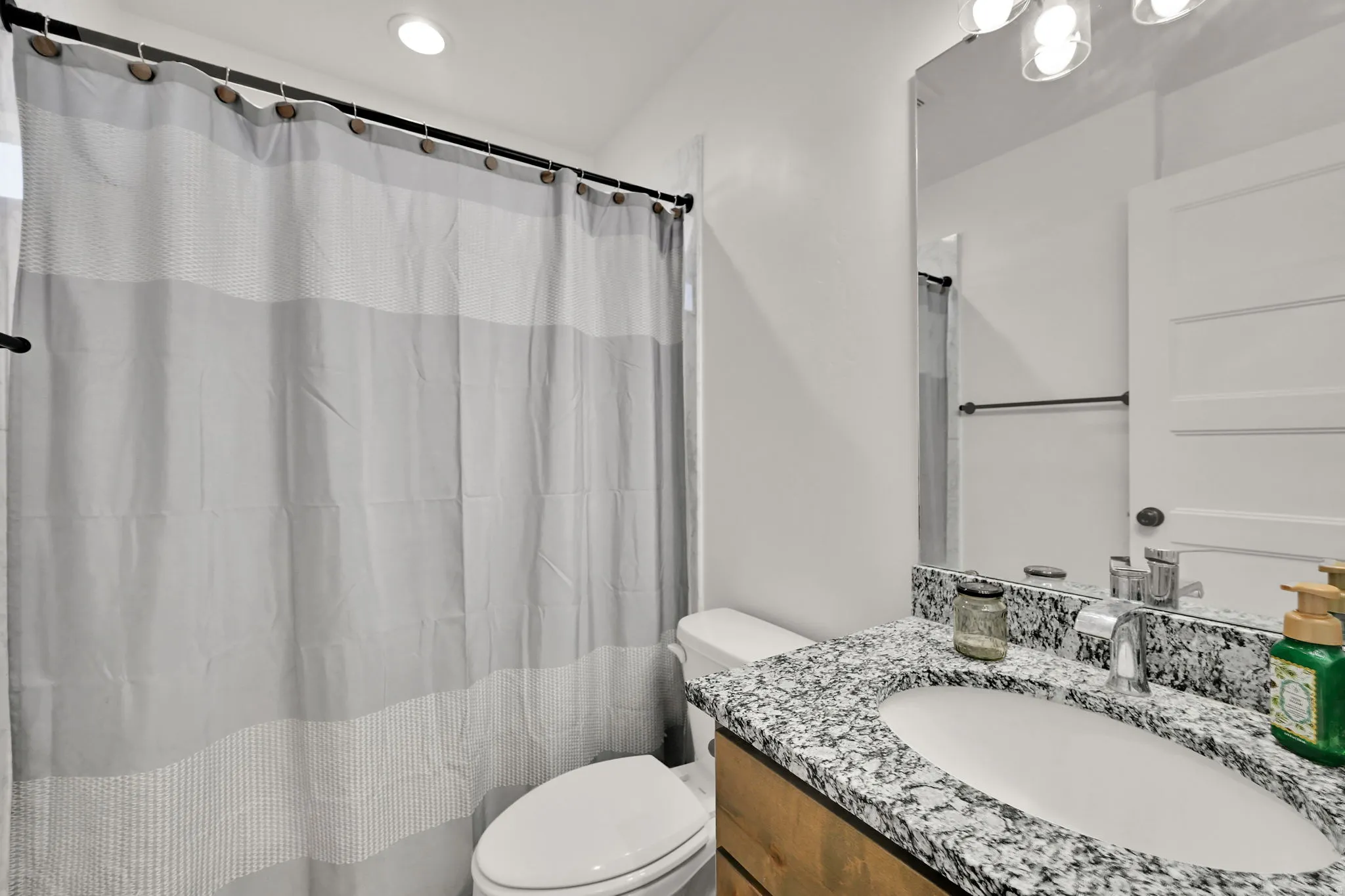 Vanity with a polished chrome faucet, under-mount sink, and granite countertop