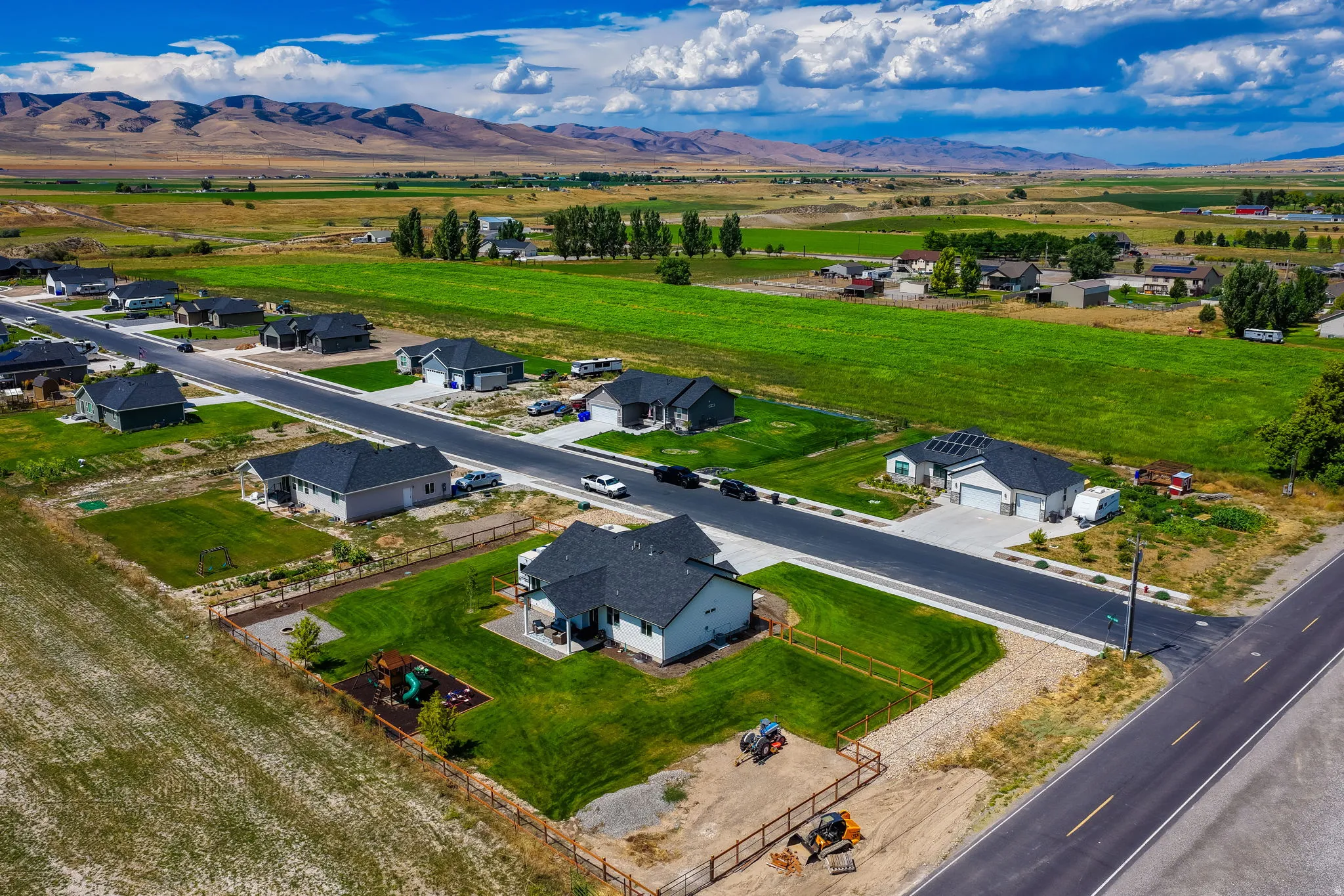 New construction homes featuring asphalt shingle roofs, attached garages, and manicured lawns