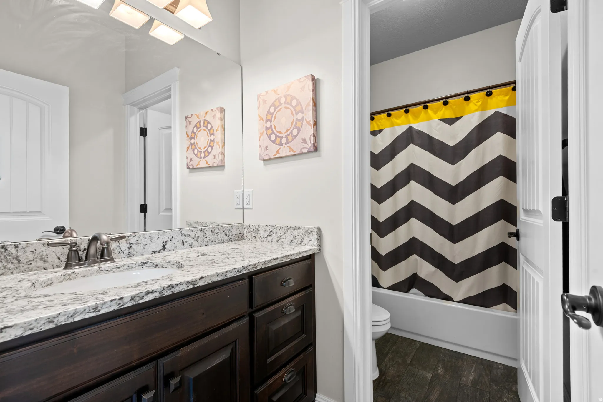 Built-in wood vanity with an integrated sink, polished chrome faucet, and expansive wall mirror