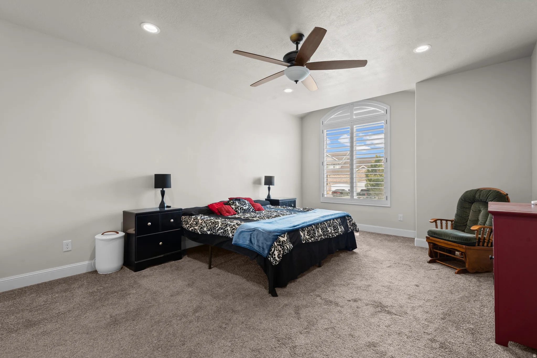 Spacious bedroom featuring recessed ceiling lighting, a ceiling fan with integrated light fixture, large windows with natural light, and neutral carpet flooring throughout