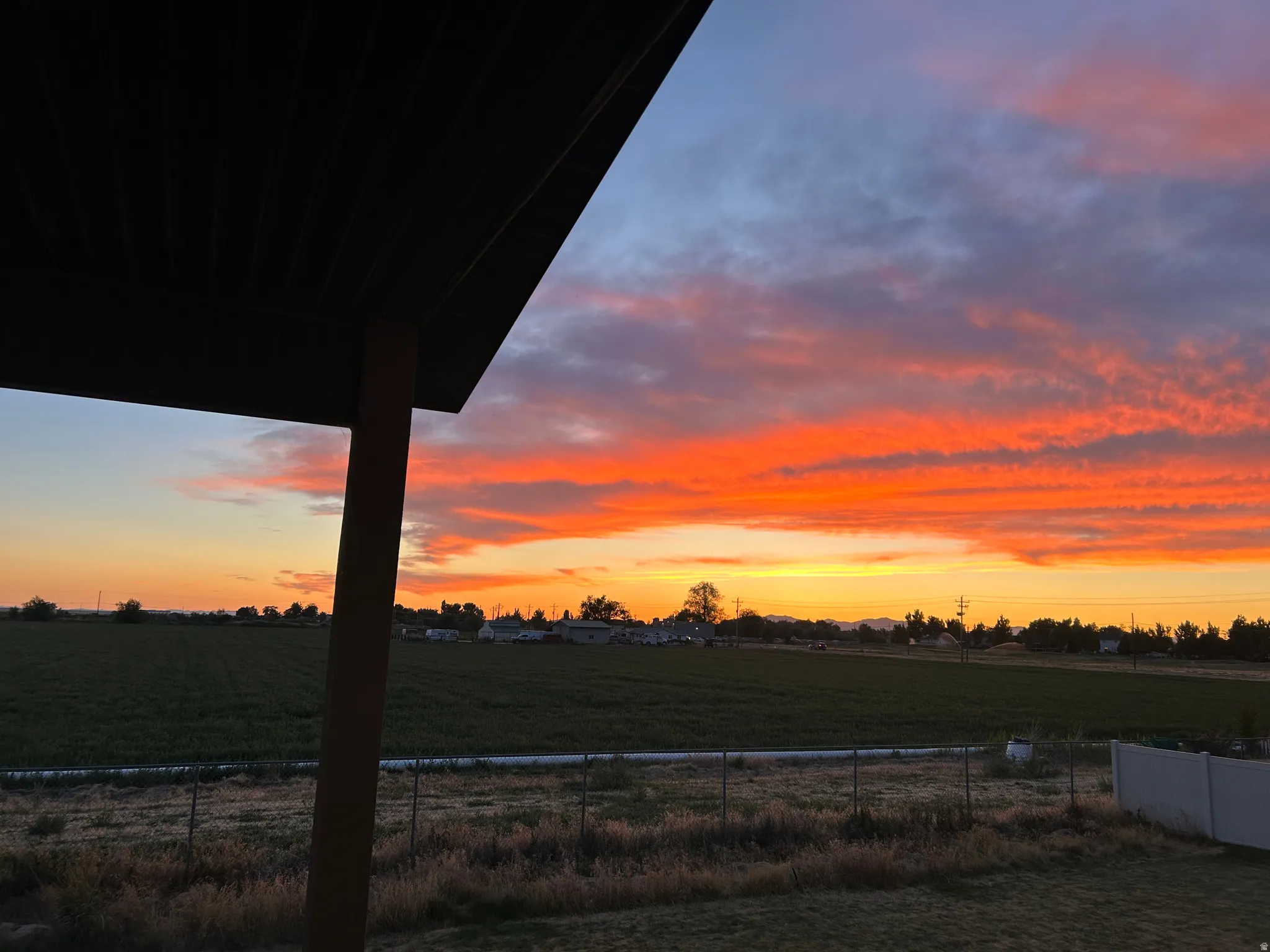 Expansive outdoor setting with a vibrant sunset and open fields