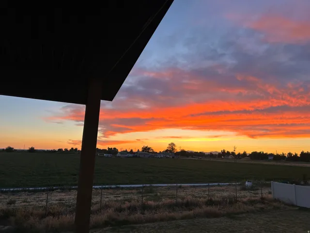 Expansive outdoor setting with a vibrant sunset and open fields