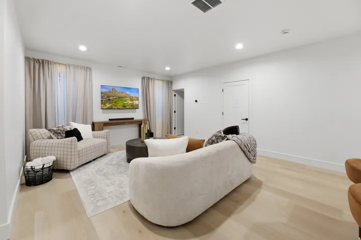Recessed lighting illuminates wood-finish flooring