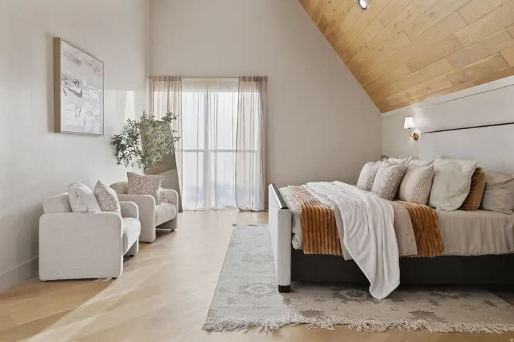 Vaulted ceiling with wood-finish paneling, recessed lighting, and wall-mounted sconces