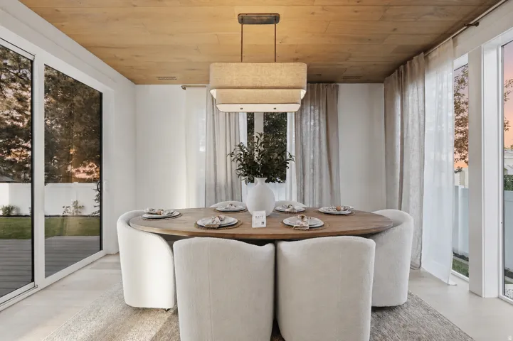 Wood-finish ceiling panels, recessed lighting, and a modern rectangular chandelier