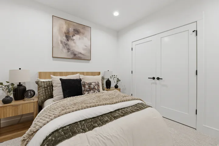 Recessed lighting, wood-finish flooring, and white paneled doors with matte black hardware
